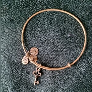 Gold Alex and Ani key bracelet with jewel